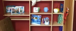 Ein Regal mit Kinderspielzeug und Büchern.