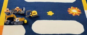 Ein Teppich mit Spielzeugfahrzeugen.
