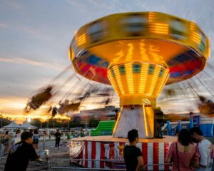 Eine Karussellfahrt in einem Vergnügungspark bei Sonnenuntergang.