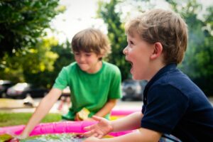 Zwei kleine Jungen spielen in einer rosa Sandgrube.