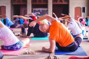 Eine Gruppe von Menschen macht Yoga in einem Außenbereich.