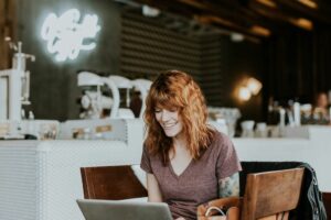 Eine Frau arbeitet in einem Café an einem Laptop.